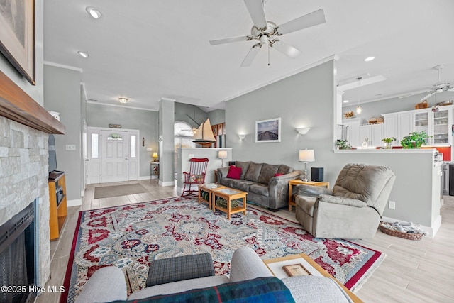 living area with ornamental molding, light wood-style floors, a fireplace, and ceiling fan