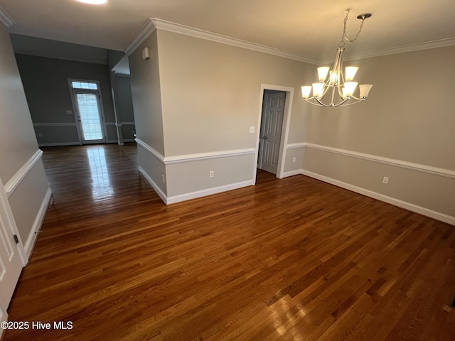 spare room with a notable chandelier, crown molding, baseboards, and dark wood-style flooring