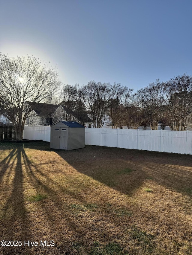 view of yard with an outbuilding, a fenced backyard, and a storage shed