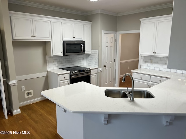 kitchen featuring crown molding, stainless steel microwave, electric range oven, white cabinetry, and a sink