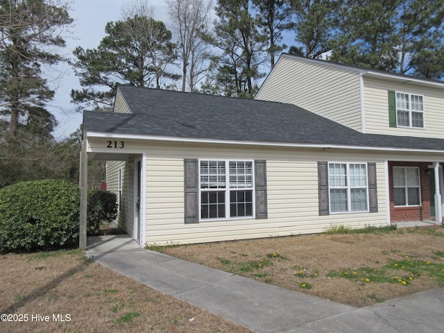 view of front of home featuring a front lawn and roof with shingles