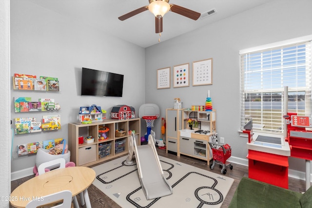 recreation room with ceiling fan, visible vents, baseboards, and wood finished floors