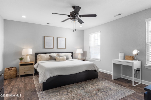 bedroom with dark wood finished floors, visible vents, a ceiling fan, and baseboards