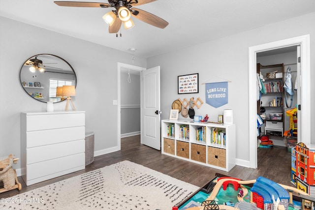 game room with baseboards, wood finished floors, and a ceiling fan