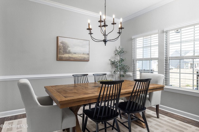 dining space featuring baseboards, wood finished floors, and crown molding