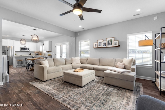 living room featuring recessed lighting, dark wood-style floors, and visible vents