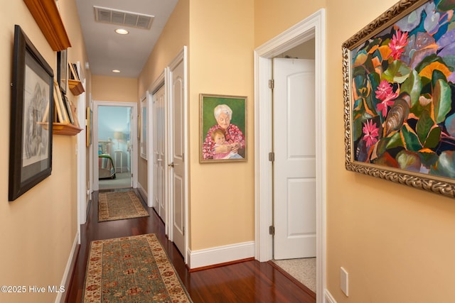 hallway with recessed lighting, visible vents, dark wood finished floors, and baseboards