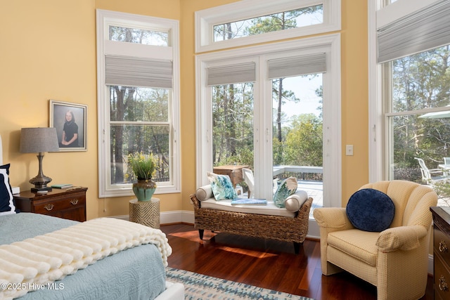 bedroom with baseboards, wood finished floors, and access to exterior