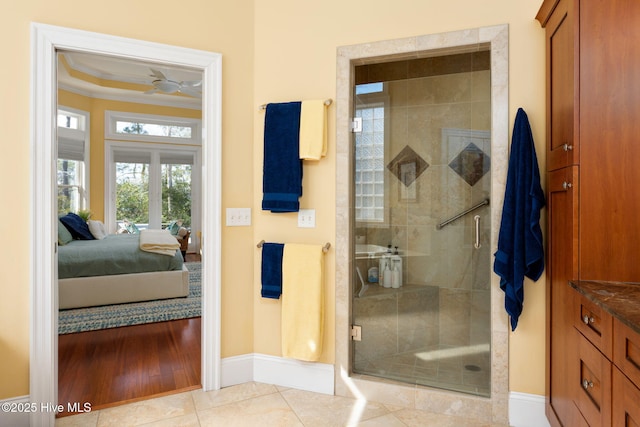 full bath with crown molding, a stall shower, connected bathroom, tile patterned flooring, and baseboards