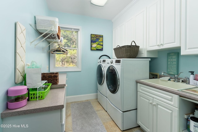 laundry room featuring cabinet space, baseboards, a sink, and independent washer and dryer