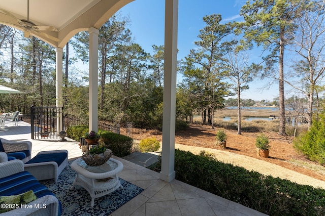 view of patio featuring ceiling fan, outdoor dining area, and a water view