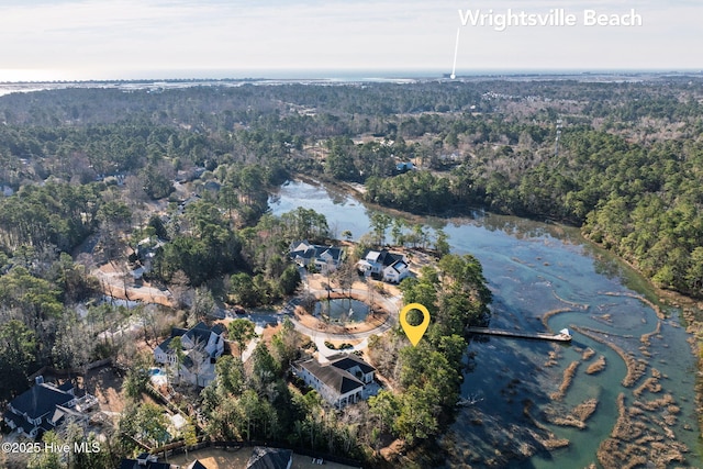 birds eye view of property featuring a water view and a wooded view