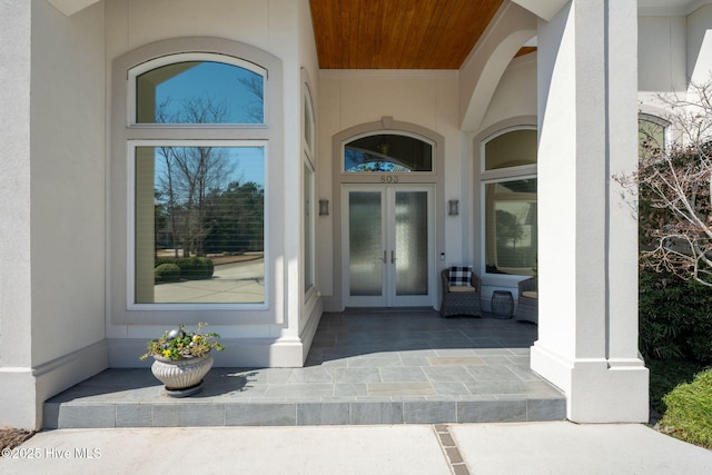 doorway to property featuring french doors and stucco siding