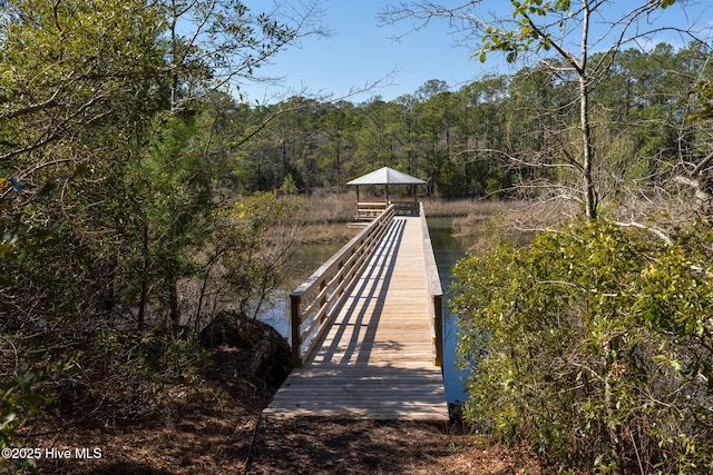 view of dock featuring a gazebo and a forest view