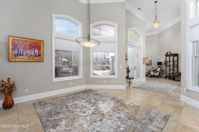 entryway with visible vents, baseboards, tile patterned flooring, a high ceiling, and crown molding