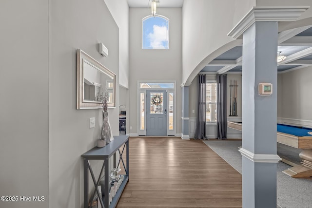 entrance foyer with a healthy amount of sunlight, a high ceiling, arched walkways, and wood finished floors