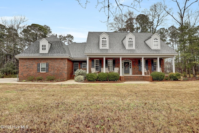 232 Creedmoor Rd, Jacksonville, NC 28546 - new england style home with a shingled roof, a front yard, brick siding, and a porch