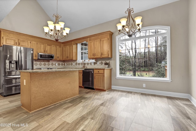 kitchen with stainless steel appliances, a notable chandelier, and tasteful backsplash