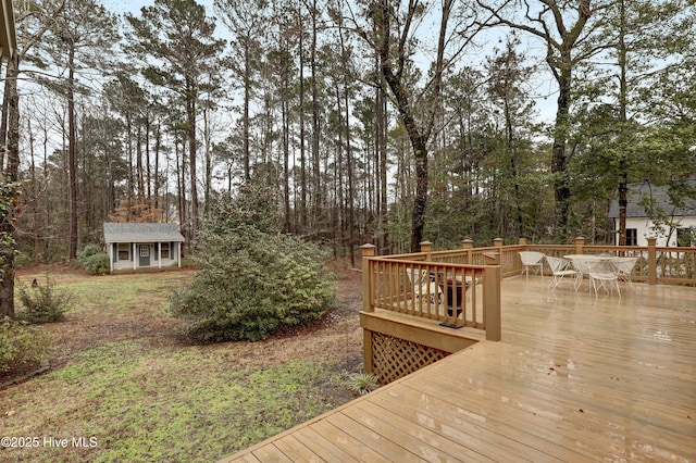 wooden deck with an outbuilding and outdoor dining area