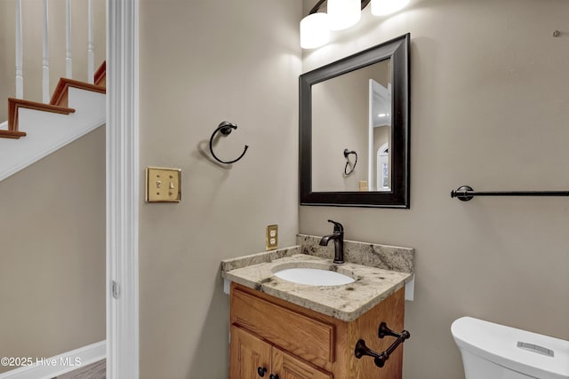 half bathroom with vanity and toilet