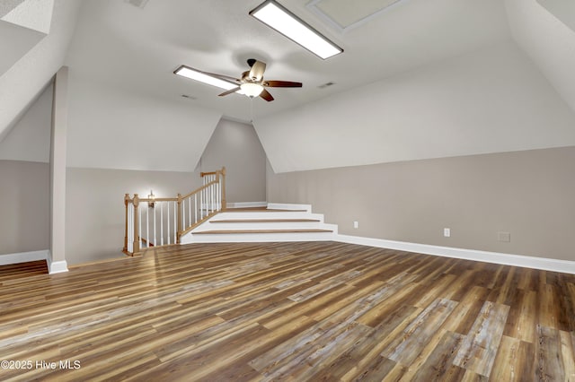 additional living space featuring lofted ceiling, ceiling fan, wood finished floors, visible vents, and baseboards