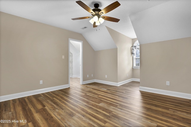 bonus room featuring baseboards, vaulted ceiling, visible vents, and dark wood finished floors