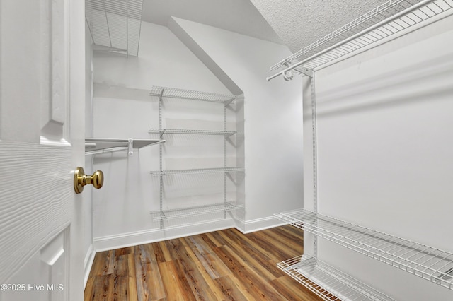 walk in closet with wood finished floors