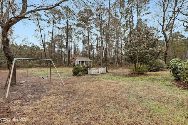 view of yard with an outbuilding, a carport, and a playground