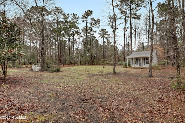 view of yard featuring an outbuilding and a view of trees