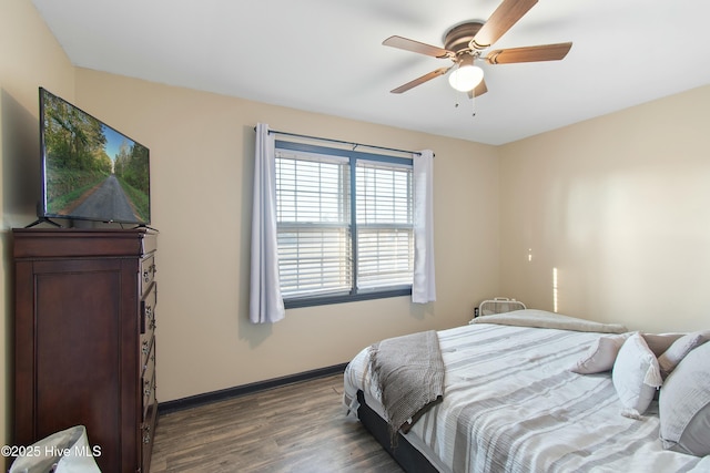 bedroom with a ceiling fan, baseboards, and wood finished floors