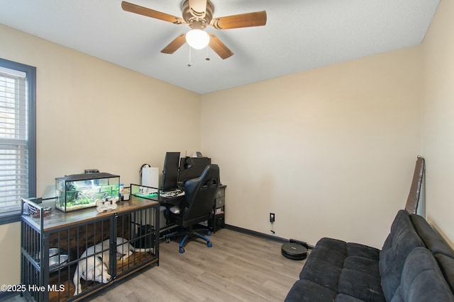 office area featuring light wood-style flooring, baseboards, and ceiling fan