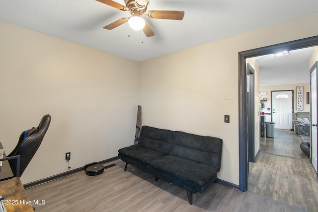 office space featuring a ceiling fan, baseboards, and wood finished floors