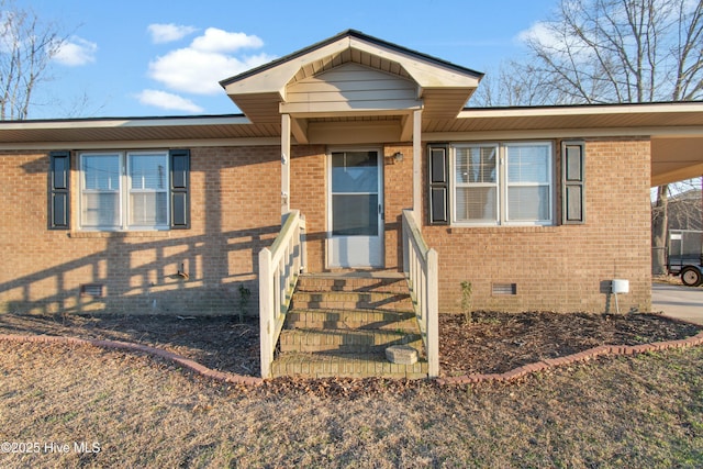 view of front of house with an attached carport, crawl space, and brick siding