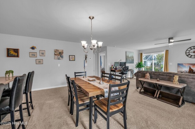 dining area with light carpet, ceiling fan with notable chandelier, and baseboards