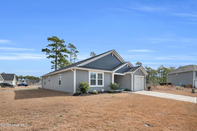 view of front of house with a garage, a front yard, board and batten siding, and driveway