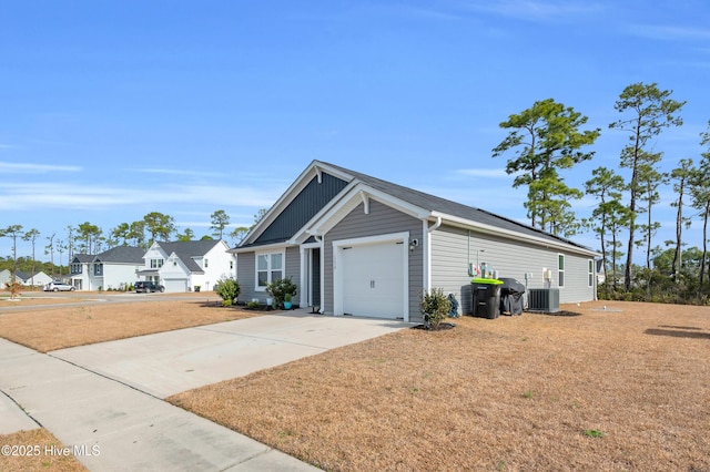 view of front facade with a residential view, concrete driveway, a garage, central air condition unit, and board and batten siding