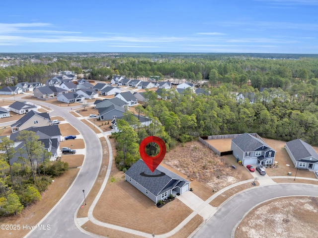 drone / aerial view with a residential view and a view of trees