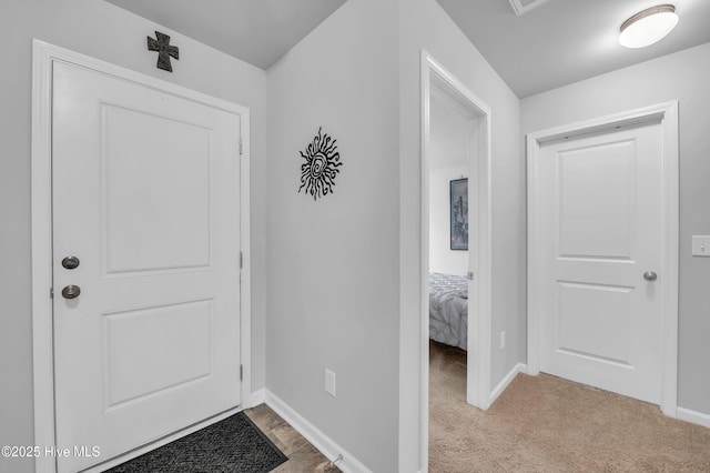 carpeted foyer entrance featuring baseboards