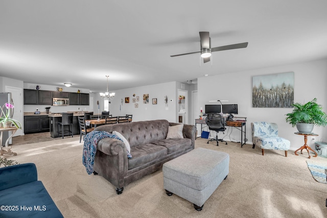 living area with light carpet and ceiling fan with notable chandelier