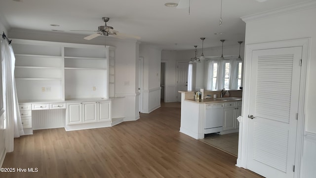 kitchen with white dishwasher, a sink, light wood-style floors, open shelves, and crown molding