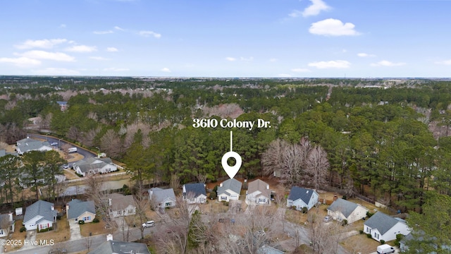 drone / aerial view featuring a residential view and a wooded view