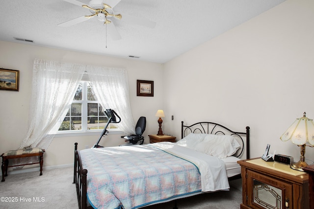 bedroom with carpet, visible vents, a textured ceiling, and baseboards