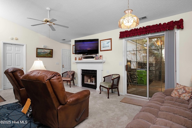 living room featuring carpet floors, visible vents, vaulted ceiling, and a fireplace