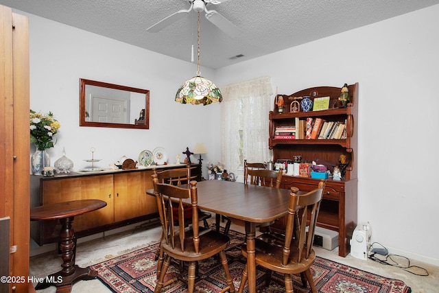 dining room with a ceiling fan, visible vents, and a textured ceiling