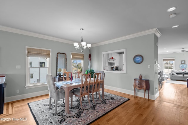 dining space with crown molding, light wood-style flooring, and baseboards