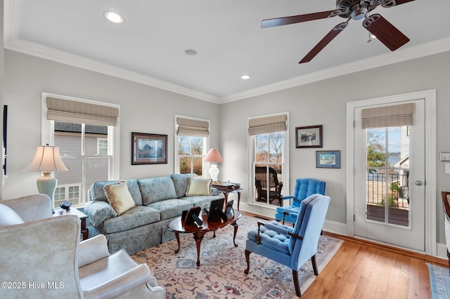 living area featuring baseboards, ornamental molding, recessed lighting, and light wood-style floors