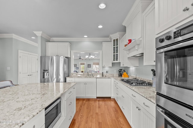 kitchen featuring glass insert cabinets, stainless steel appliances, light wood-style floors, white cabinetry, and recessed lighting