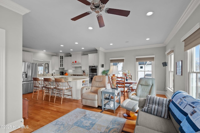 living area featuring crown molding, recessed lighting, ceiling fan, light wood-type flooring, and baseboards