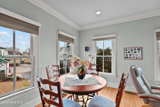 dining room featuring crown molding, baseboards, and wood finished floors