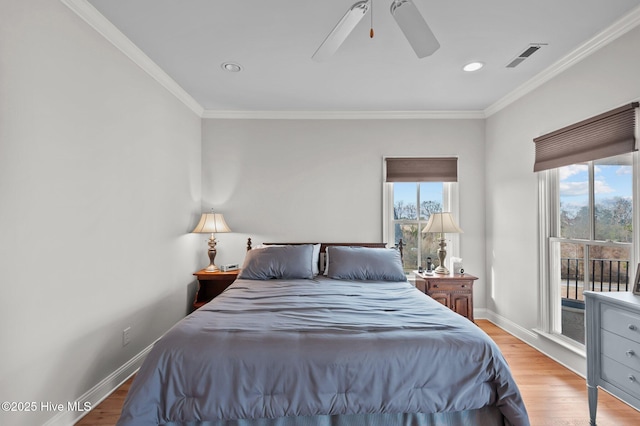 bedroom featuring ornamental molding, multiple windows, and light wood-style flooring